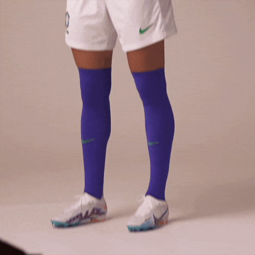 a person wearing a blue shirt and white shorts with nike written on them