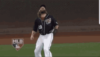 a baseball player with the number 28 on his jersey is catching a ball .
