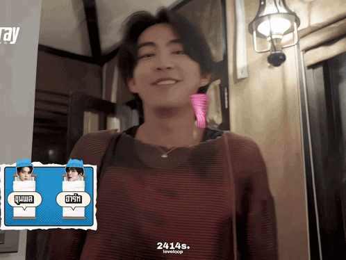 a man in a red sweater is smiling in front of a sign that says 24145