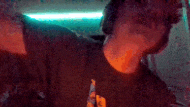a blurry picture of a man holding a beer bottle
