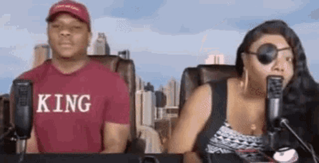 a man and a woman are sitting next to each other in front of microphones .