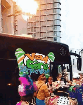 a group of people are gathered in front of a van care stripe tour bus with flames coming out of it