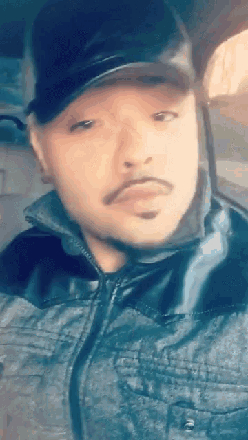 a man wearing a black hat and a denim jacket