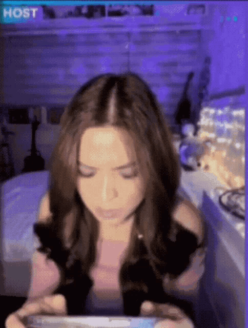 a woman is playing a video game on her phone with the word host on the bottom