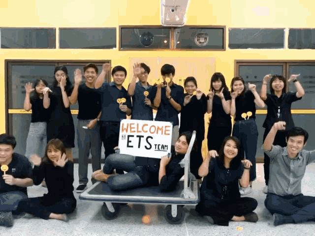 a group of people holding lollipops and a sign that says " welcome ets team "