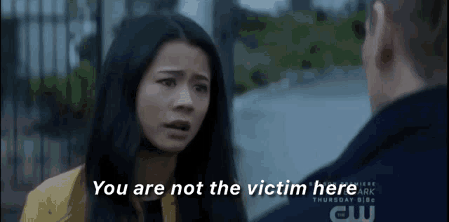 a woman talking to a man with the words " you are not the victim here " on the screen