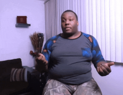 a man in a gray and blue shirt is holding a sword