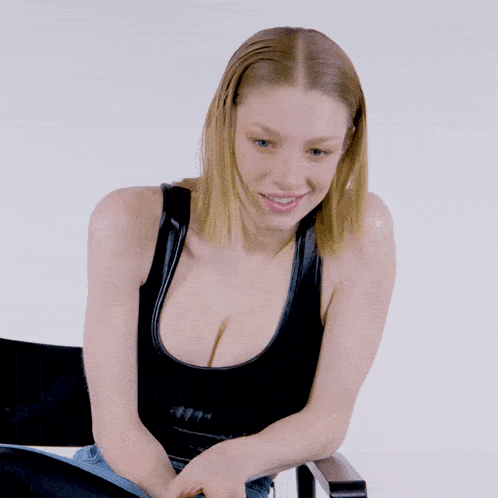 a woman in a black tank top is smiling