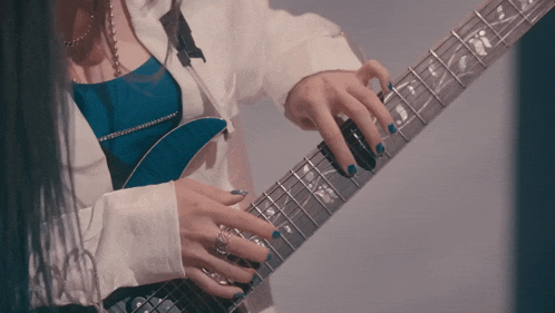 a woman with blue nails is playing a blue guitar