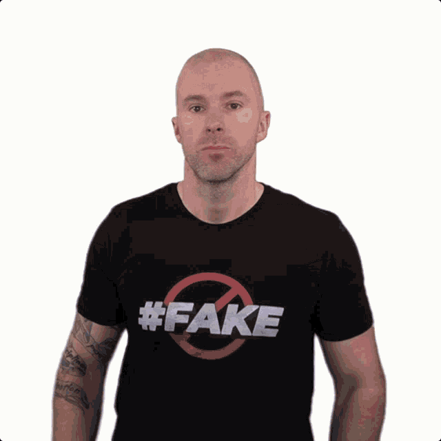 a man wearing a black shirt that says # fake on it