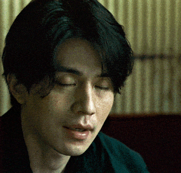 a man with his eyes closed looks down at something