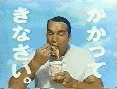 arnold schwarzenegger is eating a cup of noodles with chinese writing behind him .