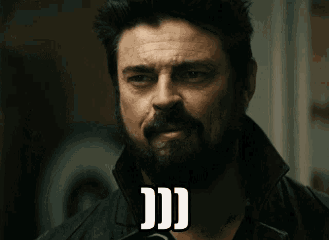 a man with a beard and a black jacket has the letters jj on his face