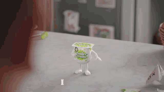 a figurine of a box of fresh fruity yogurt with arms and legs
