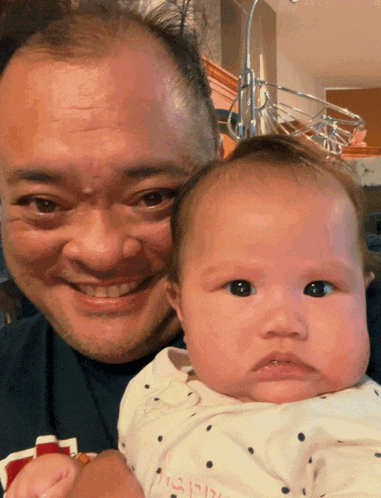 a man is holding a baby with a shirt that says i 'm a girl