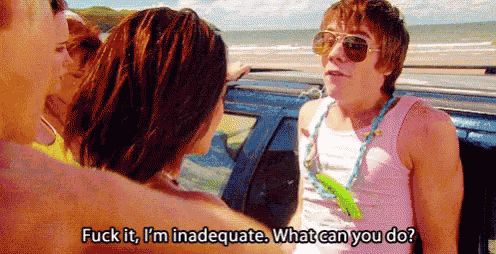 a man in sunglasses is talking to a group of people while standing next to a car on the beach .