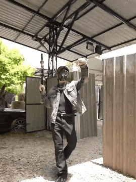a man wearing a gas mask is holding a gun in his hand