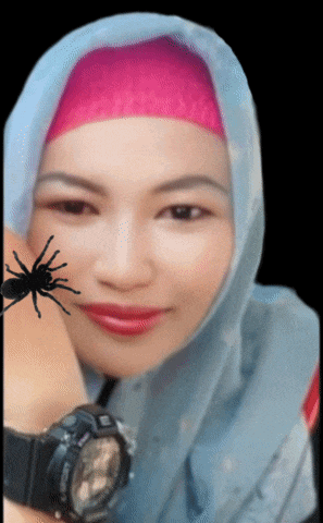a woman wearing a hijab holds a spider on her face