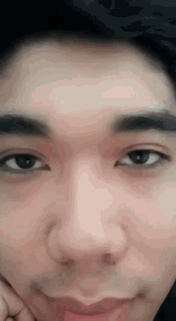 a close up of a person 's face with their hand on their chin
