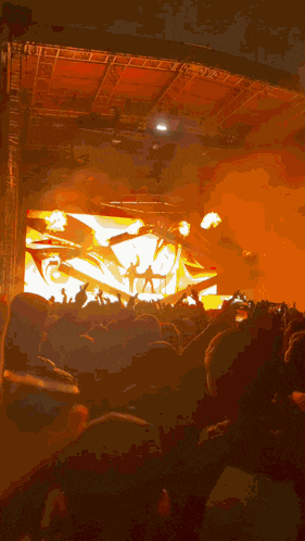 a crowd of people at a concert with a large screen behind them that says ' i love you ' on it