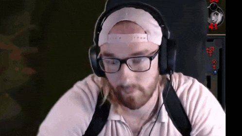 a man with glasses and headphones is playing a video game