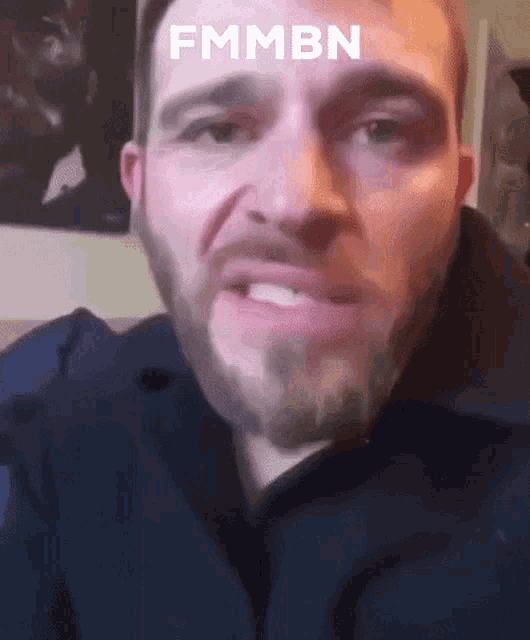 a man with a beard is making a funny face with the words fmmbn above his head