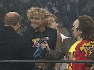 a man holding a microphone in front of a crowd that says nbc