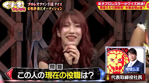 a woman with red hair is smiling in front of a picture of a man and a lion
