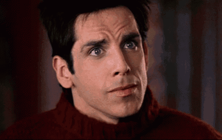 a close up of a man wearing a red sweater making a funny face