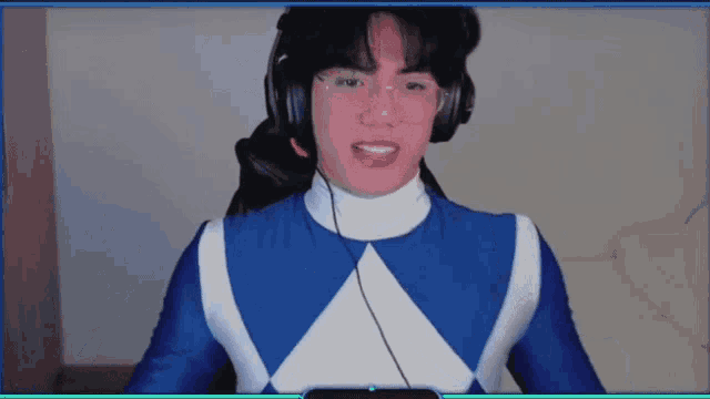a man in a blue and white power ranger costume is wearing headphones and glasses