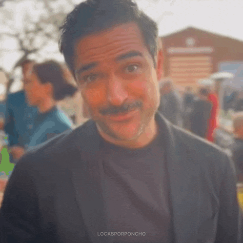 a man with a mustache is wearing a black jacket