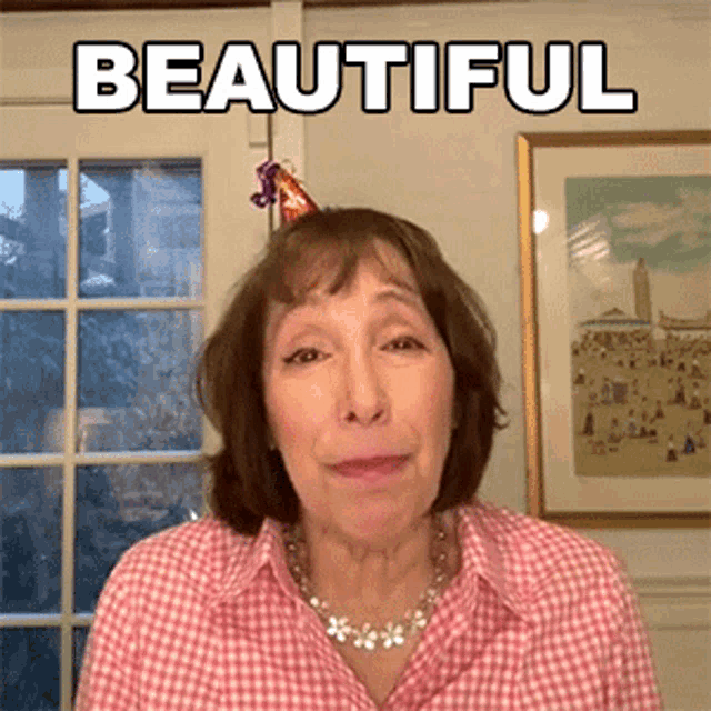 a woman wearing a party hat with the word beautiful above her head