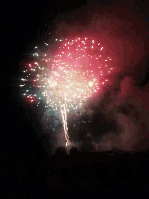 a fireworks display with red white and green fireworks