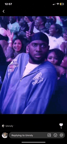 a man in a purple jacket is standing in front of a crowd of people