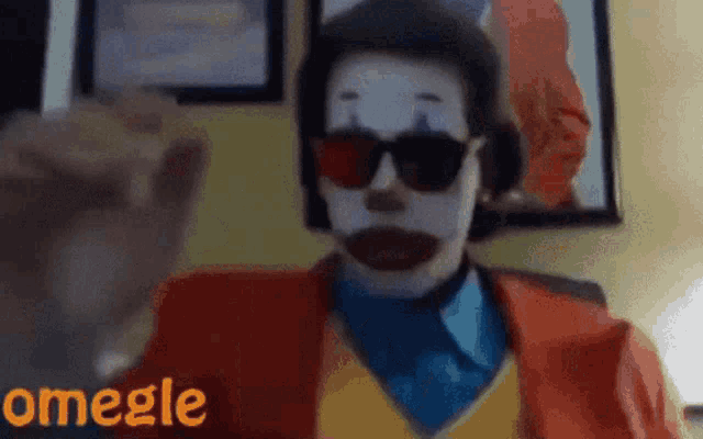 a man dressed as a clown wearing sunglasses and a suit says omegle on the bottom