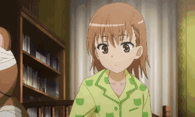 a girl with brown hair is wearing a yellow and green pajama shirt