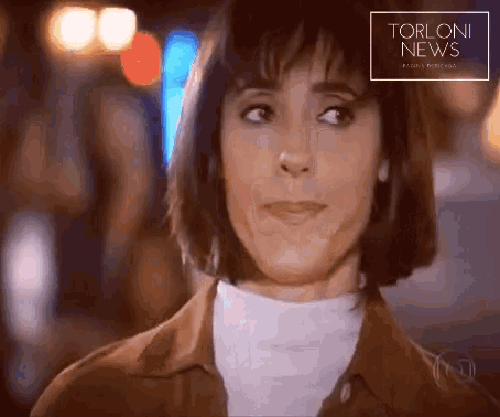 a close up of a woman 's face with the words torloni news written above her