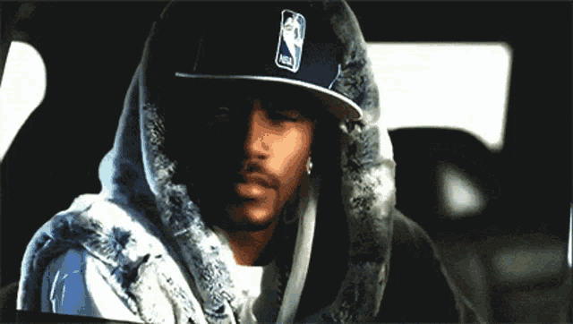 a man wearing a nba hat and a fur hoodie
