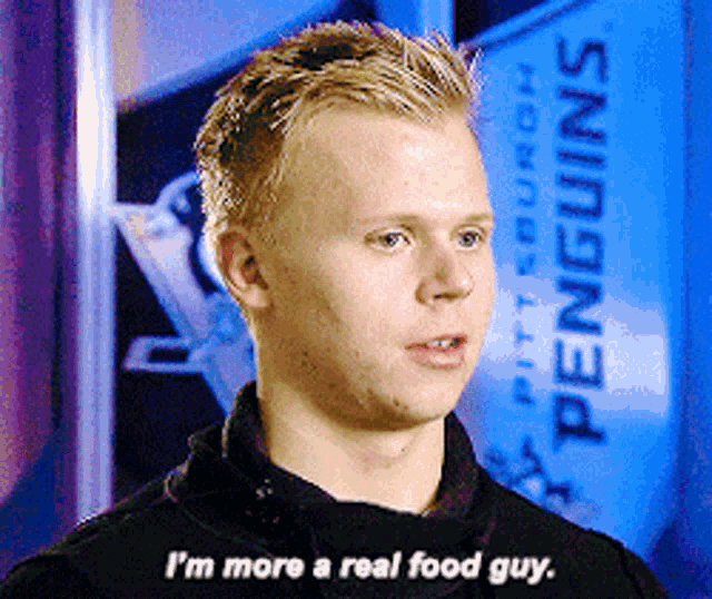 a man in front of a sign that says pittsburgh penguins