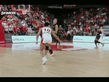 a basketball player wearing a number 10 jersey is dribbling the ball