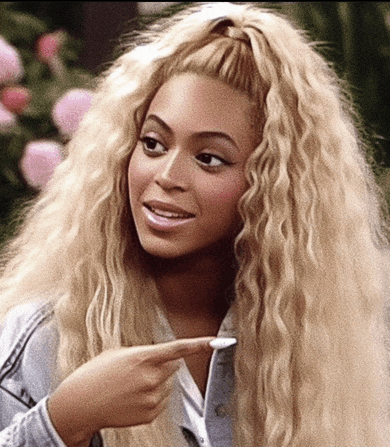 a woman with blonde curly hair is pointing her finger at something
