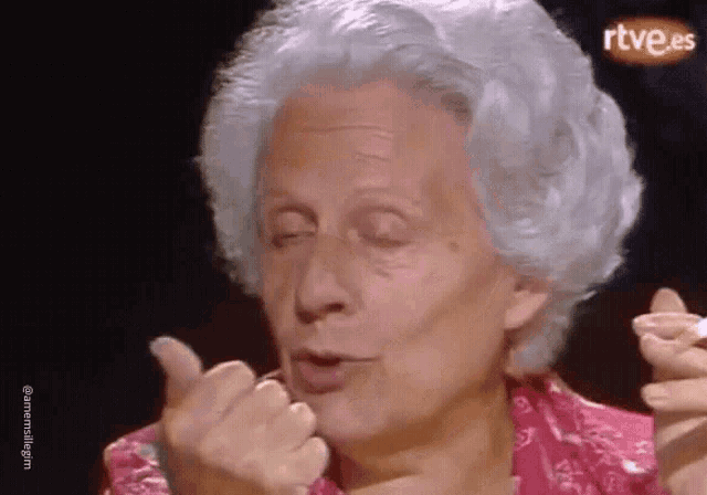 an older woman with gray hair is giving a thumbs up