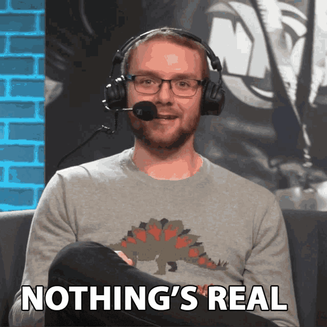 a man wearing headphones and a sweater that says nothing 's real