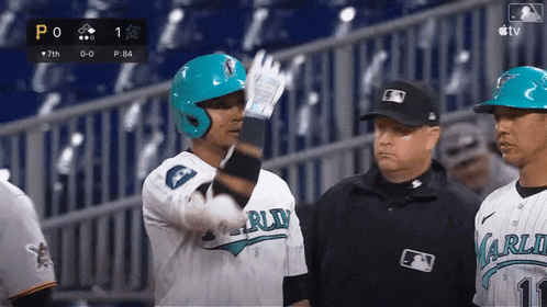 a baseball player wearing a blue helmet is talking to a referee