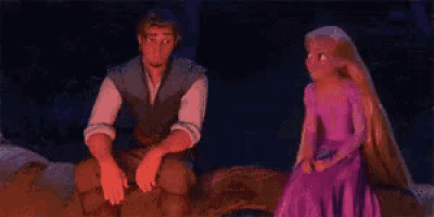 a man and a woman are sitting next to each other and the woman is wearing a purple dress .