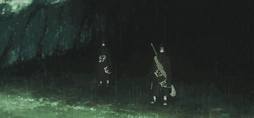 a couple of people standing next to each other in the dark holding guns .
