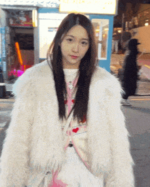 a woman wearing a white fur coat stands in front of a sign that says ice cream shop