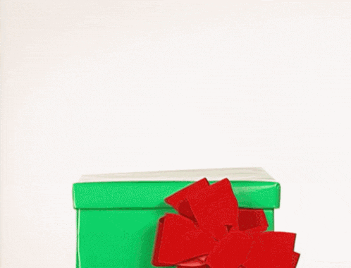 a green christmas gift box with a red bow on it