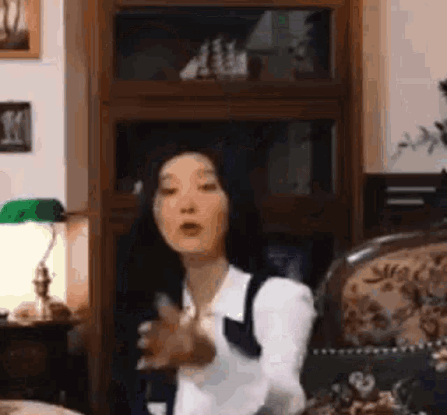 a woman is sitting in a chair in a living room holding a remote control .