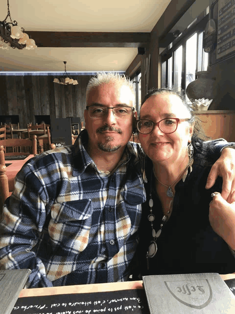 a man and woman are posing for a picture in a restaurant